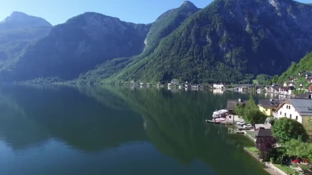 オーストリアの松の木の森の山の真ん中に鏡面湖の水の魅力的な4Kの空中ドローンのパノラマショット — ストック動画