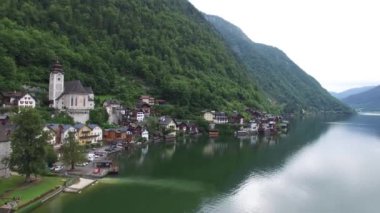 Antik ev aynası yüzey gölü sahili üzerinde büyüleyici 4k hava aracı uçuşu. Vahşi doğa dağ manzarası.