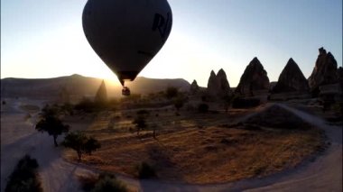 Rengarenk sıcak hava balonunun muhteşem hava manzarası taştan kaya çölünün üzerinde akşam üstü gökyüzünde uçuyor.