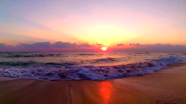 穏やかな景色の海辺の風景で素晴らしいオレンジ色の暖かい夜の夕日で砂のビーチにクラッシュする海の波 — ストック動画