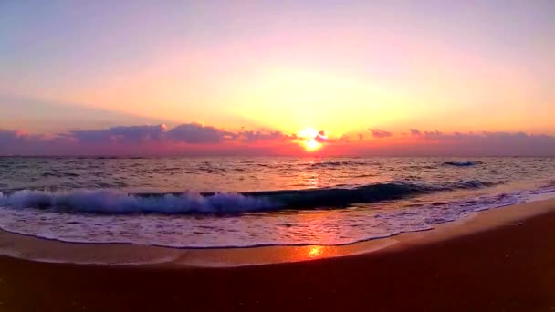 穏やかな景色の海辺の風景で美しいオレンジ色の暖かい夜の夕日で砂のビーチにクラッシュする海の波 — ストック動画