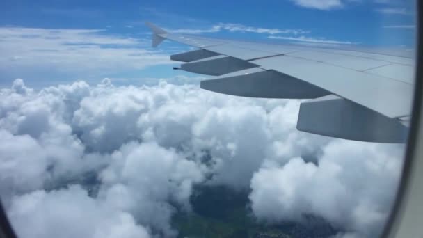 澄んだ青い空に白いふわふわの雲の上を飛んでいる飛行機の窓からの壮大な空の景色 — ストック動画