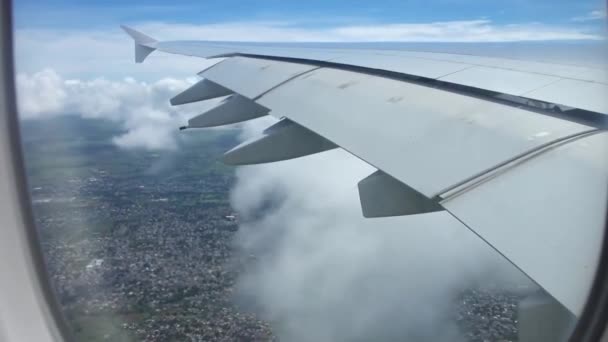 Belle vue aérienne depuis la fenêtre de l'avion sur l'aile de l'avion volant haut au-dessus des nuages blancs et duveteux dans un ciel bleu clair 