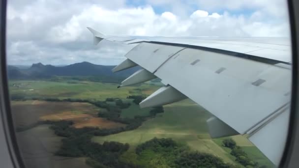 飛行機の窓から見える緑豊かな森の上を 真っ青な空に白いふわふわの雲の中を飛ぶ — ストック動画