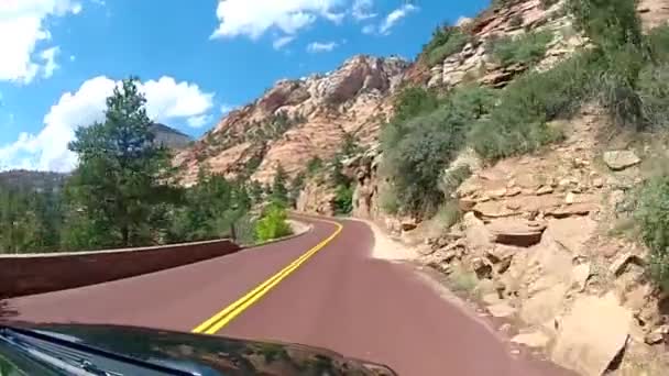 美しい赤砂石の山の丘の峡谷の風景の中に高速下り坂アスファルト道路田舎の高速道路を運転 — ストック動画