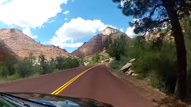 壮大な赤い砂石の山の丘の峡谷の風景の中に高速下り坂アスファルト道路田舎の高速道路を運転 — ストック動画