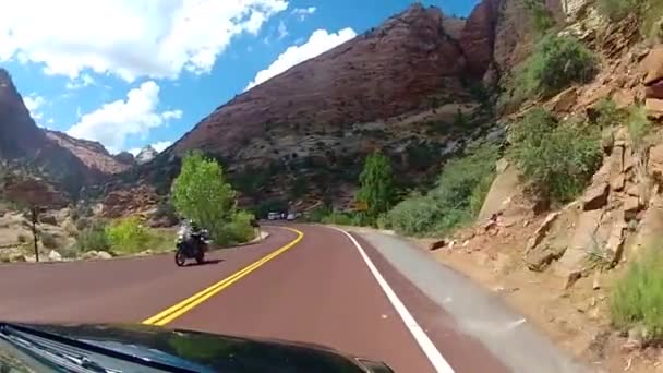 壮大な赤い砂石の山の丘の峡谷の風景の中に高速下り坂アスファルト道路田舎の高速道路を運転 — ストック動画