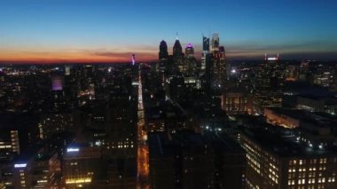 Göz kamaştırıcı 4k hava aracı gökyüzünde turuncu günbatımında akşam gökyüzünde Philadelphia 'nın büyük şehri