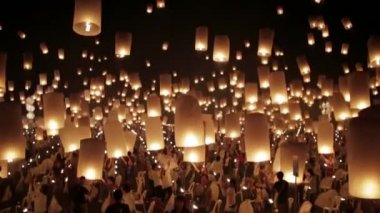 Mutlu insanlar binlerce ışık saçan Çin kâğıdı fenerlerini karanlık gece festivalinde gökyüzüne salıyorlar.