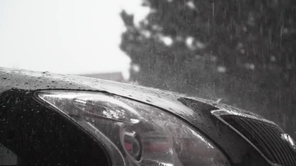 在黑色湿淋淋的新式汽车盖帽前灯上 雨滴平静下落时 视觉上令人满意的慢镜头 — 图库视频影像