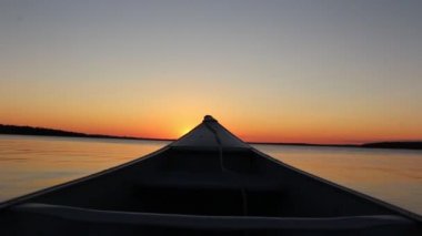 Resimli sıcak turuncu akşam günbatımını gören ilk kişi sakin ayna yüzeyi nehir manzaralı kano teknesinden