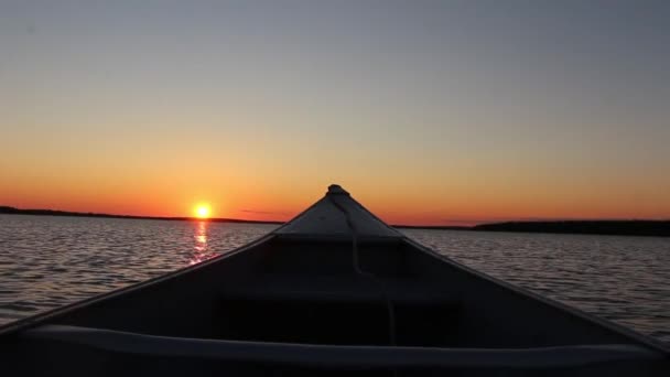 穏やかな鏡面川の湖の風景でカヌーボートから素晴らしい暖かいオレンジの夕日に最初の人のPovビュー — ストック動画