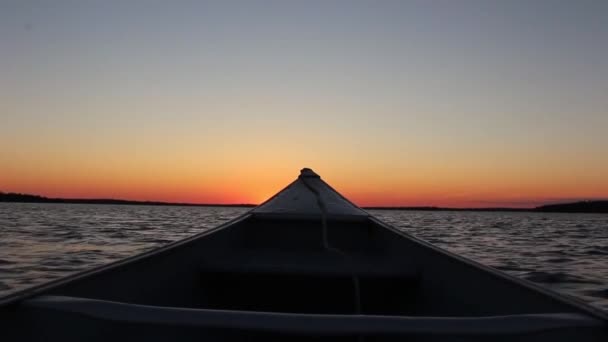 穏やかな鏡面川の湖の風景の中にカヌーボートから雄大な暖かいオレンジの夜の夕日最初の人のPovショット — ストック動画
