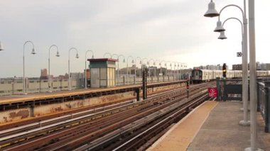 İki çarpıcı modern şehir merkezi çelik metro treni bulutlu bir günde tren istasyonuna varıyor.