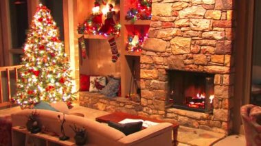 Yılbaşı arifesi muhteşem Noel ağacı oda dekorasyonu şöminede yanan odunların atmosfer döngüsü.