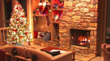Şenlikli, hoş bir Noel ağacı dekorasyon atmosferinde şöminede yanan odunların döngü görüntüsü.