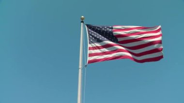 İnanılmaz ulusal sembol Amerikan bayrak yıldızı ve çizgili pankart mavi gökyüzü güneşli arka planında rüzgarda dalgalanıyor