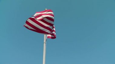 Çarpıcı ulusal sembol Amerikan bayrak yıldızı ve şerit pankartı mavi gökyüzü güneşli arka planında rüzgarda dalgalanıyor