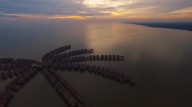 Lüks turizm üzerine görkemli hava aracı görüntüsü Avani Sepang Gold Coast tatil beldesi Malezya tropikal okyanus günbatımı deniz manzarası