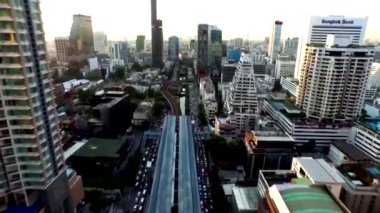 Büyük metropol şehri Bangkok 'un yüksek gökdelen kulesi üzerinde nefes kesen insansız hava aracı uçuşu.