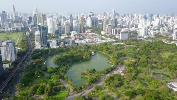 Stunning green nature lake park in middle of busy downtown big modern Bangkok downtown Thailand aerial cityscape flyover — 비디오