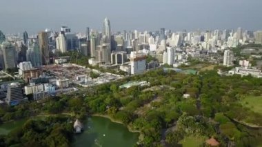 Gorgeous green nature lake park in middle of big modern busy downtown Bangkok downtown Thailand aerial cityscape flyover