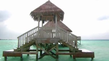 Minik ahşap bungalov lüks otel dairesi Turkuaz okyanus suyundaki Maldivler Adası deniz manzaralı tropik cennet