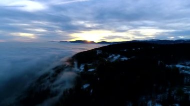 Yoğun yağış bulutu bulutu altında, akşam günbatımı dağ manzarasında nefes kesen hava aracı 4k panorama üstgeçişi.