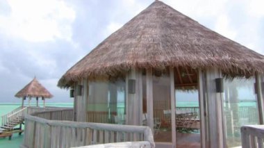 Turkuaz okyanus tropik cenneti Maldivler Adası 'ndaki ahşap bungalov otel dairesinin güzel, sabit çekimi.