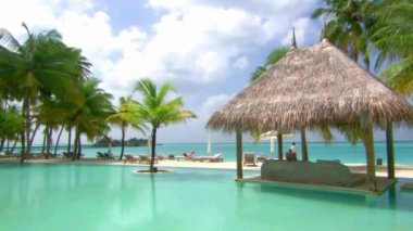 Maldivler adası turkuaz okyanus palmiyeleri tropik cennette lüks bir tatil köyünde yüzme havuzu manzarası