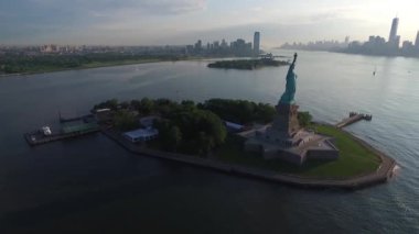 Birleşik Devletler 'in Amerikan Özgürlük Heykeli' nin ıssız ada okyanus günbatımındaki muhteşem hava aracı görüntüsü.