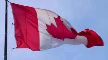 Büyüleyici ulusal sembol Kanada bayrağı kırmızı akçaağaç yaprağı bayrağı mavi gökyüzünde rüzgarda dalgalanıyor.