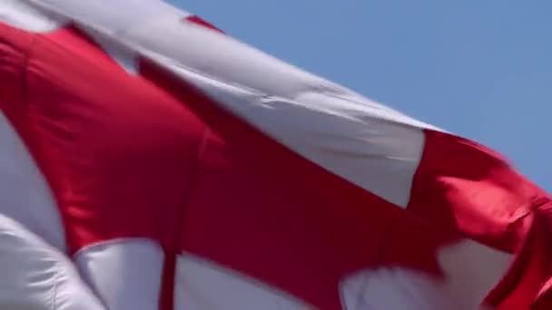 Gros plan sur l'époustouflant drapeau d'érable rouge blanc symbole national Bannière du Canada agitant dans le vent sur fond de ciel bleu 