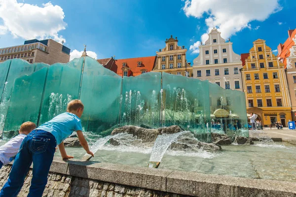 Niños jugando con fuentes en la Plaza del Mercado en Wroclaw —  Fotos de Stock