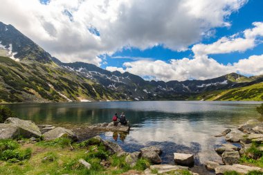 Polonya Tatras beş havuz vadisinde bir kayaya oturan turist birkaç 