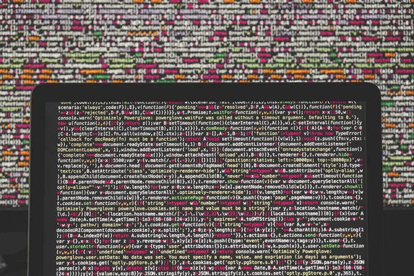 Layar laptop dengan kode sumber di depan tampilan yang lebih besar — Stok Foto
