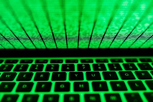 Tela do laptop com código binário verde brilhando no escuro — Fotografia de Stock