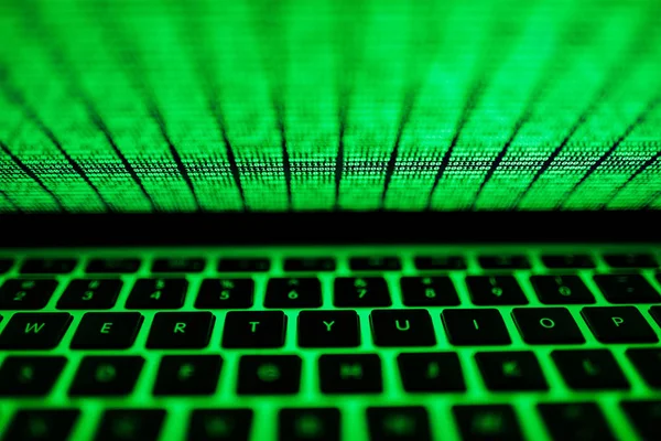 Layar laptop dengan kode biner hijau menyala dalam gelap — Stok Foto