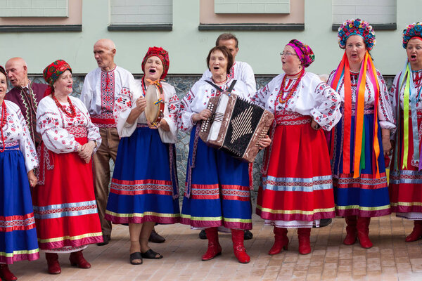 Народный ансамбль в традиционной украинской национальной одежде выступает на улице Киева, Украина - июль 2012
