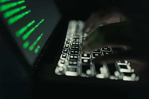 Conceito de crime cibernético: mãos de uma pessoa que invade um laptop na escuridão — Fotografia de Stock
