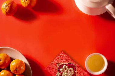 Kırmızı zarfın üzerindeki çeviri metni: Refah ve İlkbahar. Çin Yeni Yılı ve Ay Yeni Yılı kutlamaları kırmızı zarf turuncu ve sıcak çay.