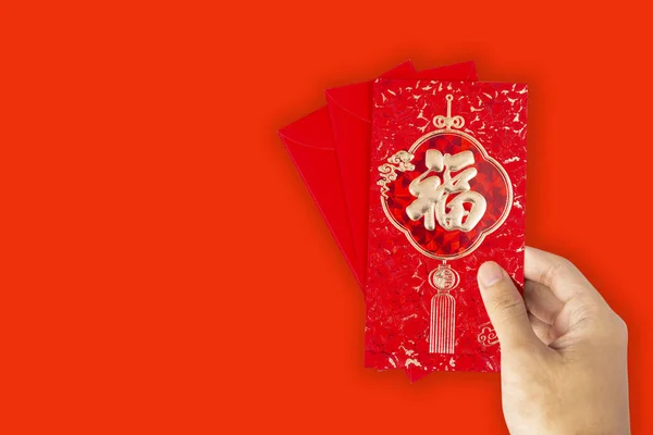 Translation text on red envelope in image: Prosperity and Spring. Hand Hold red envelope for Chinese New Year or Lunar New Year celebrations mean all things going smooth and well.