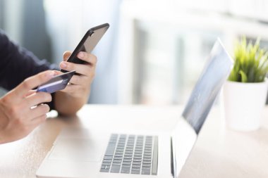 Adam mavi tişört giyer Akıllı telefon ve kredi kartı yakası olan eller