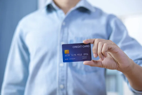 Homem mão segurando frente cartão de crédito desgaste camisa — Fotografia de Stock