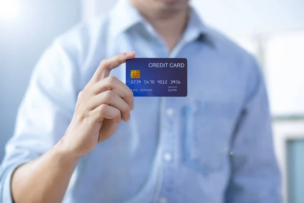 Homem mão segurando frente cartão de crédito desgaste camisa — Fotografia de Stock