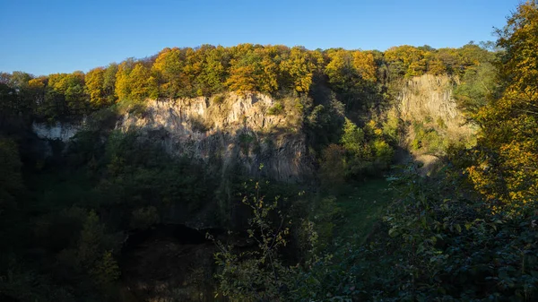 Panoramic view of the rock wall of the Weilbergsee with autumn forest in the evening light. — Stock Photo, Image