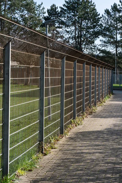 Stalowy płot na chodniku na przedmieściach. — Zdjęcie stockowe