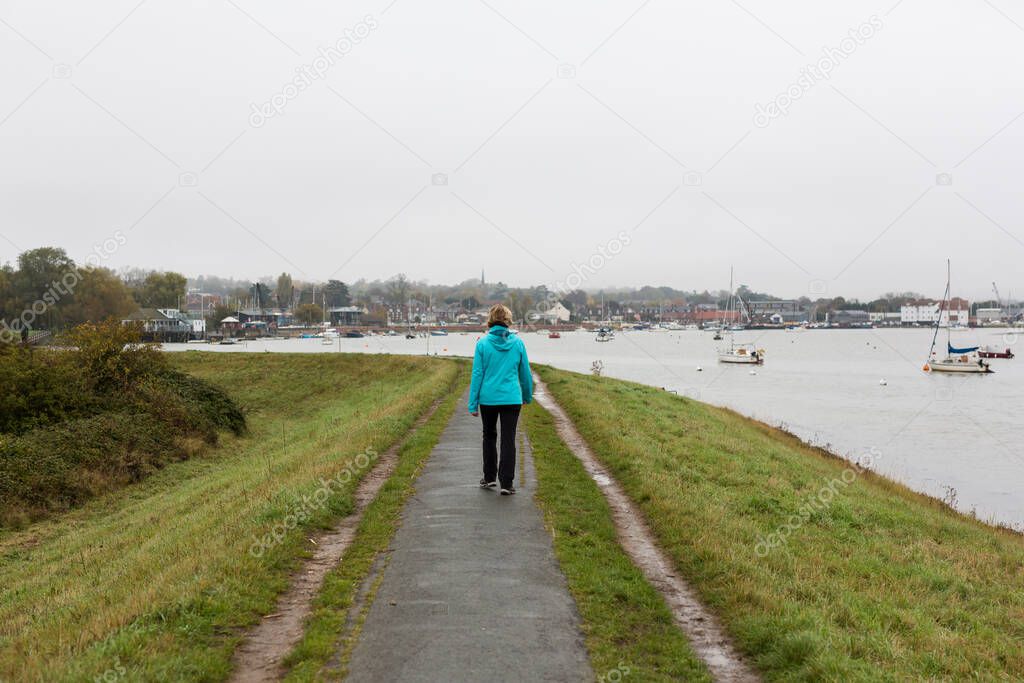 A middle aged couple taking their dog for a walk through the countryside