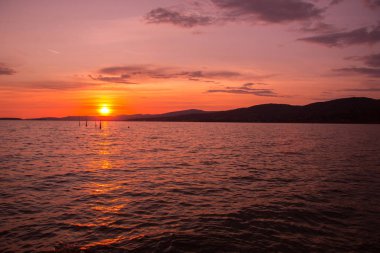Mavi gökyüzü ve gün batımıyla manzaralı göl manzarası