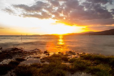 Mavi gökyüzü ve gün batımıyla manzaralı göl manzarası
